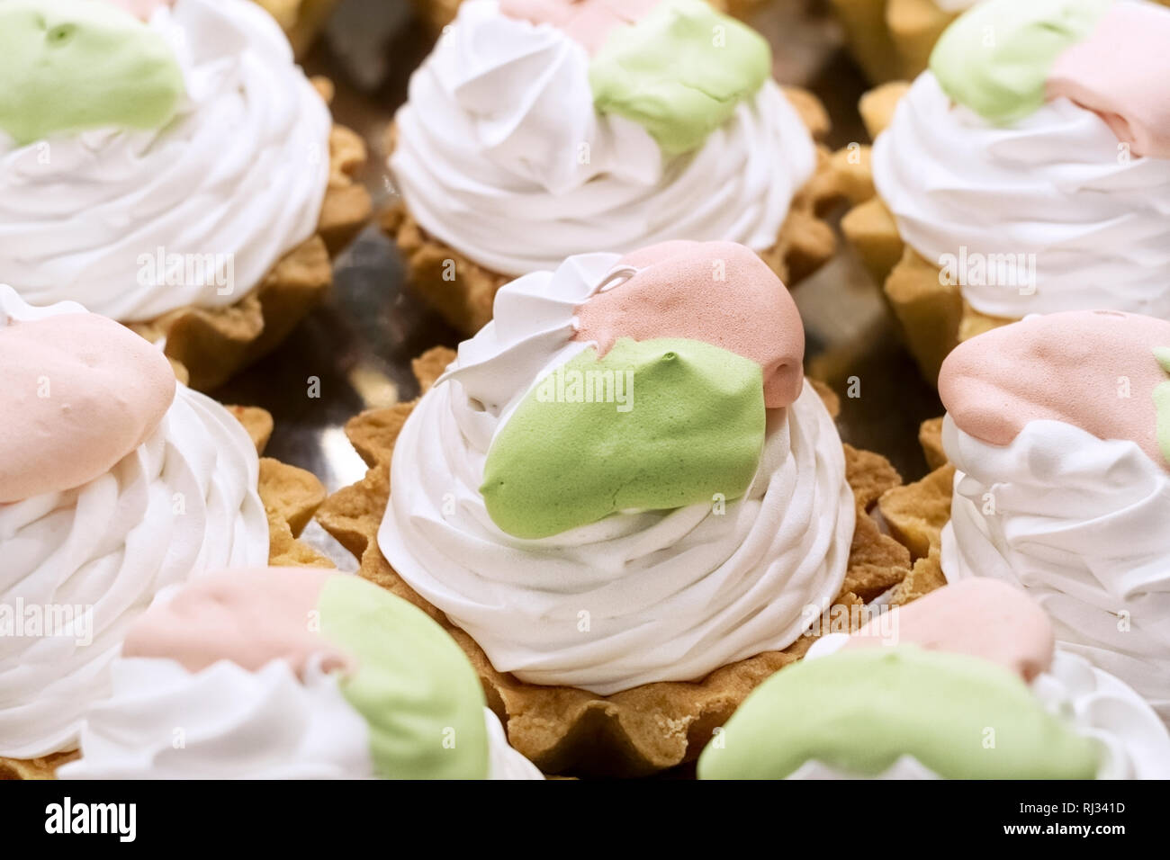 Torte cestini di pasta frolla con meringa bianca e rosa crema verde Foto Stock