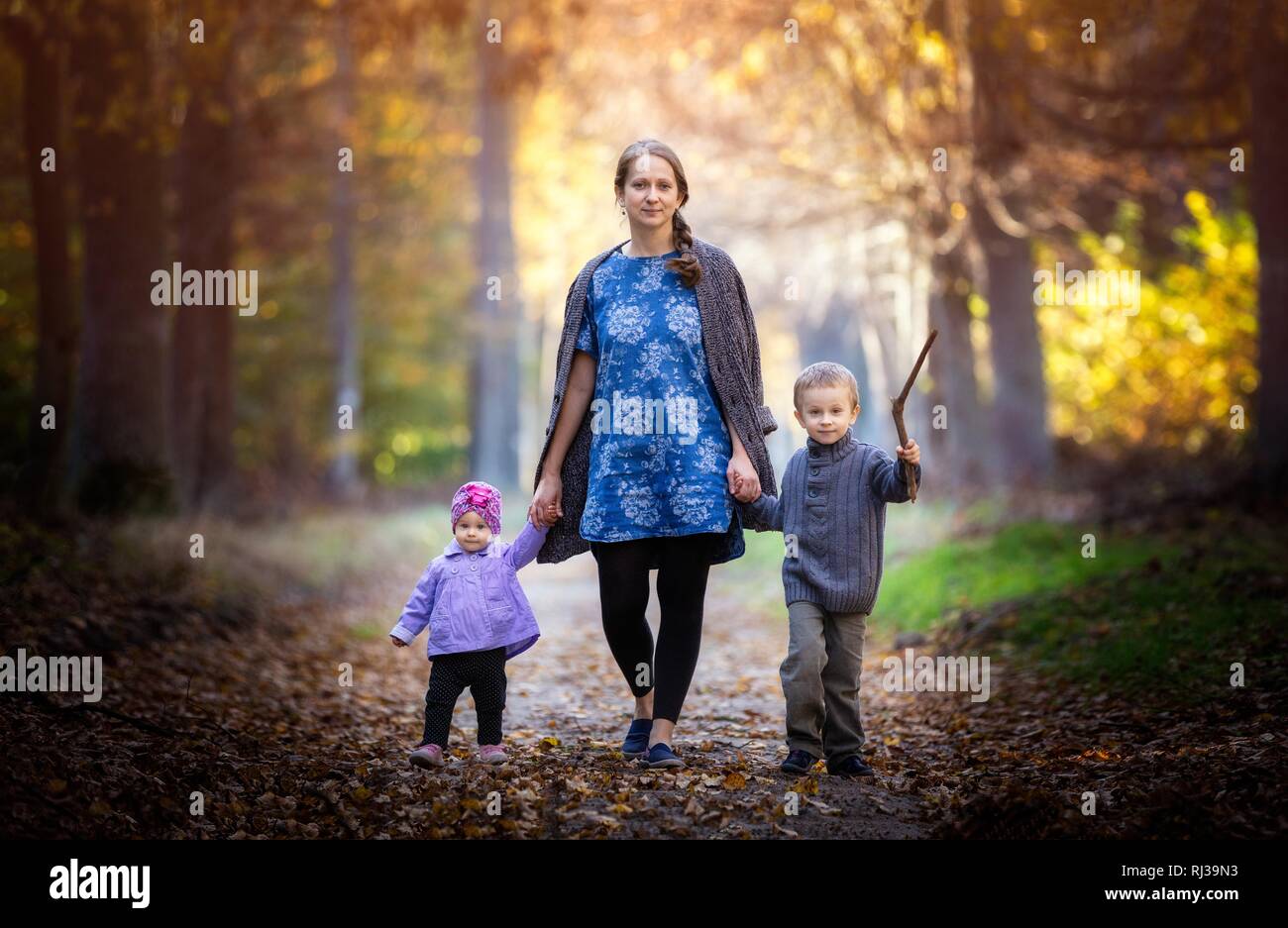 Piuttosto caucasian bambino e la madre nel paesaggio autunnale. La famiglia felice godere di colori autunnali. Foto Stock