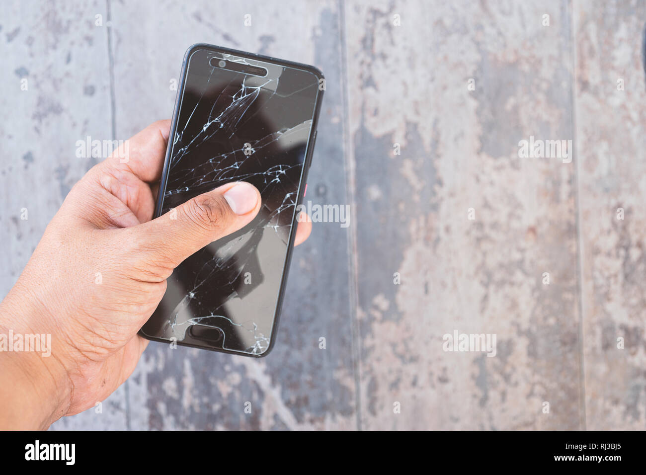 Mano che tiene la smartphone rotto Foto Stock