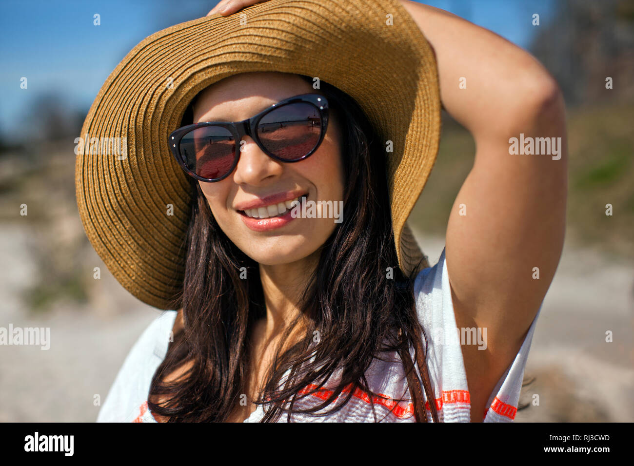 Donna che indossa cappello per il sole in spiaggia. Foto Stock