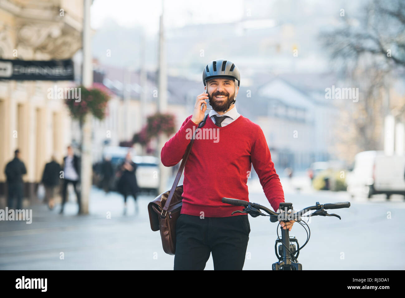 Hipster imprenditore commuter con bicicletta sullo smartphone e sul modo di lavorare in città. Foto Stock