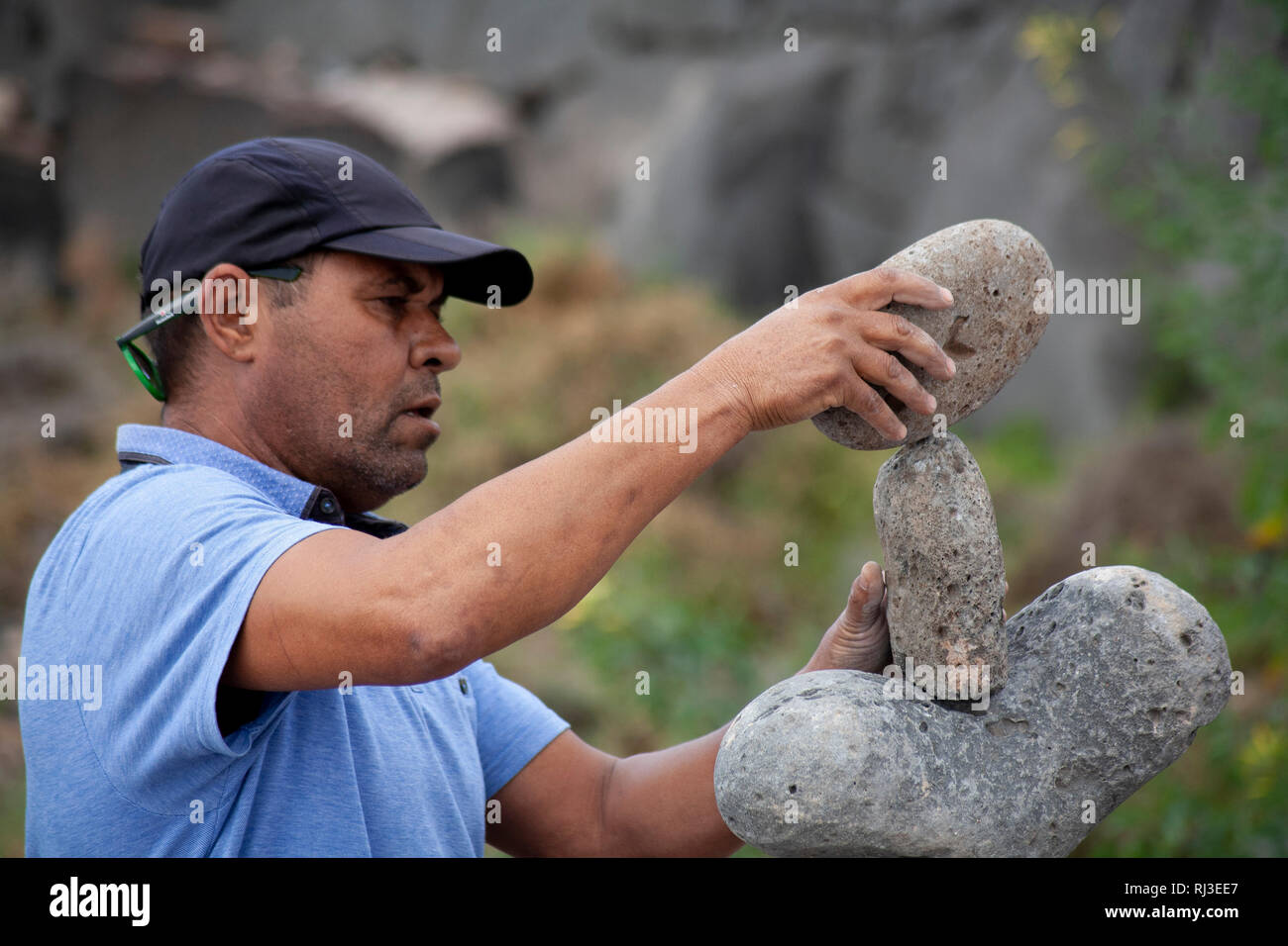 Uomo sulla spiaggia di rocce di bilanciamento. Foto Stock