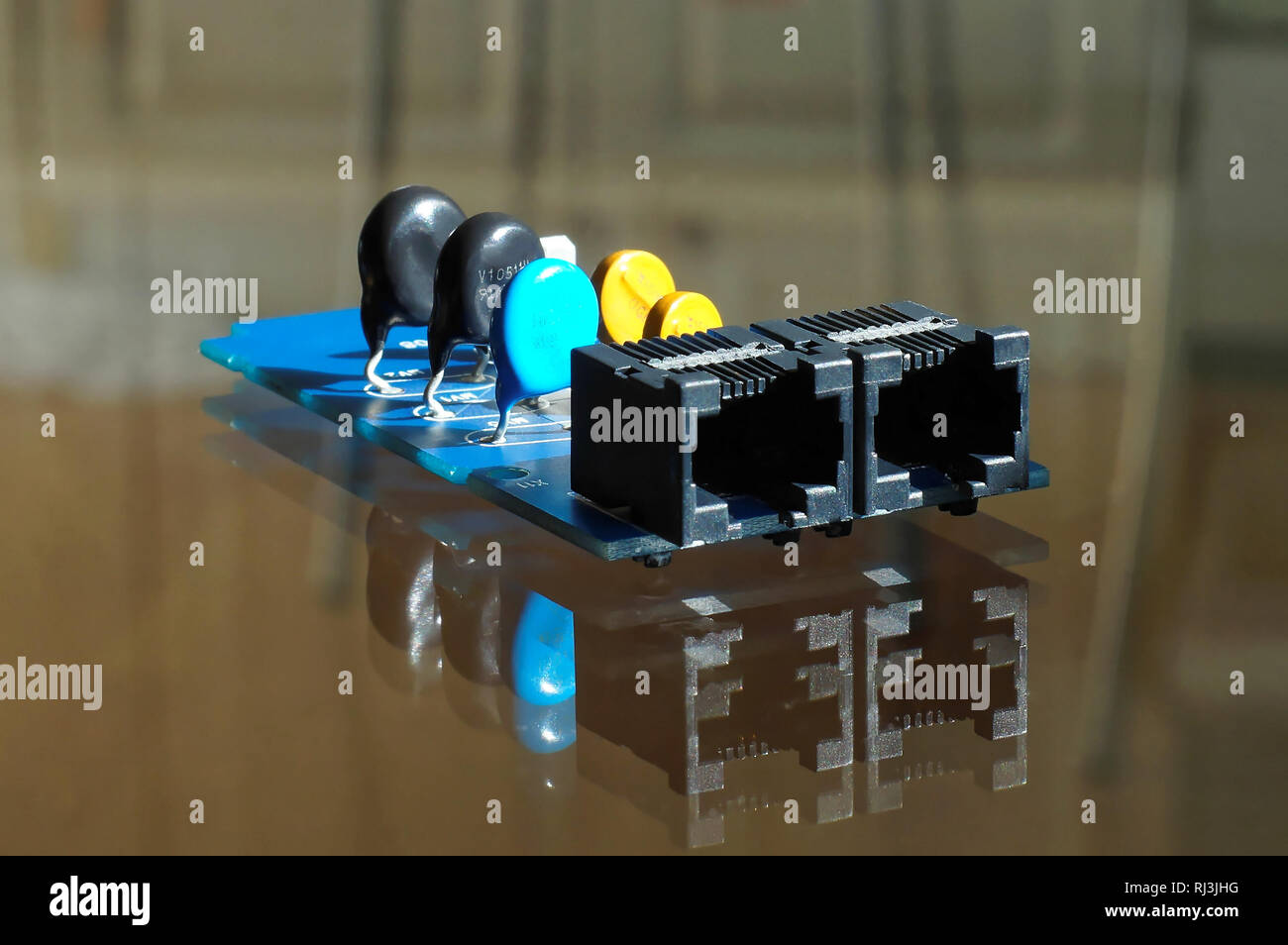 Apparecchiatura elettronica - nero, blu e giallo componenti elettronici montati sulla scheda di circuito stampato - Circuito stampato con rete o prese di telefono in Foto Stock