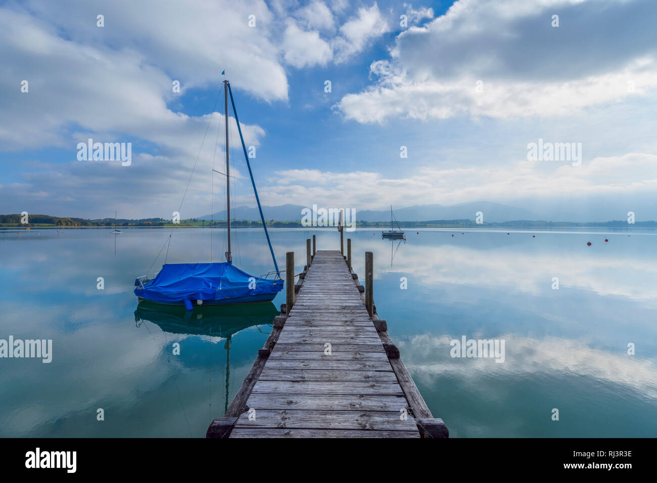 Pontile in legno con barca, Lago di Forggensee, Dietringen, Svevia, Allgau, Baviera, Germania Foto Stock