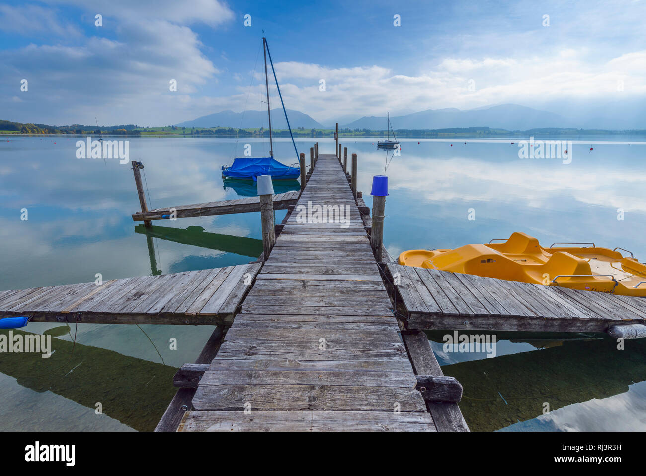 Pontile in legno con barca, Lago di Forggensee, Dietringen, Svevia, Allgau, Baviera, Germania Foto Stock