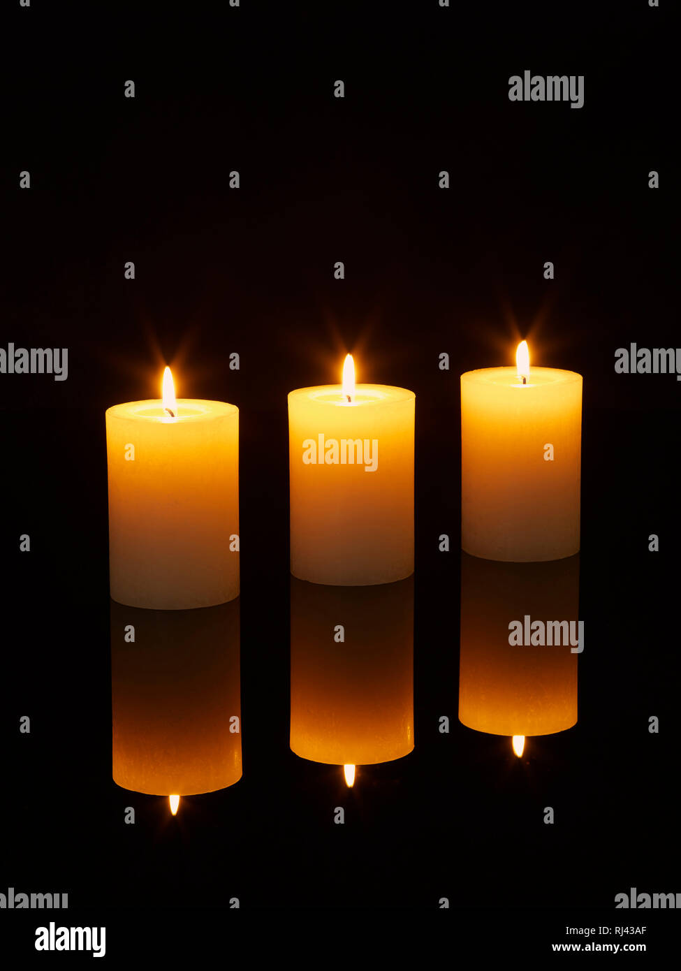 Kerzen mit Spiegelung angez?ndet auf einem Tisch Foto Stock