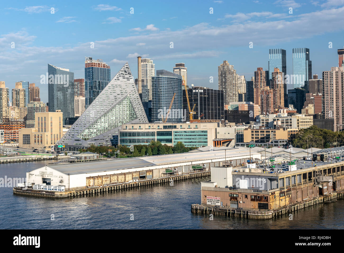 La città di New York skyline di Manhattan con la nave è ormeggiata lungo la costa e via 57 West, una a forma di piramide edificio residenziale da Bjarke Ingels. Foto Stock