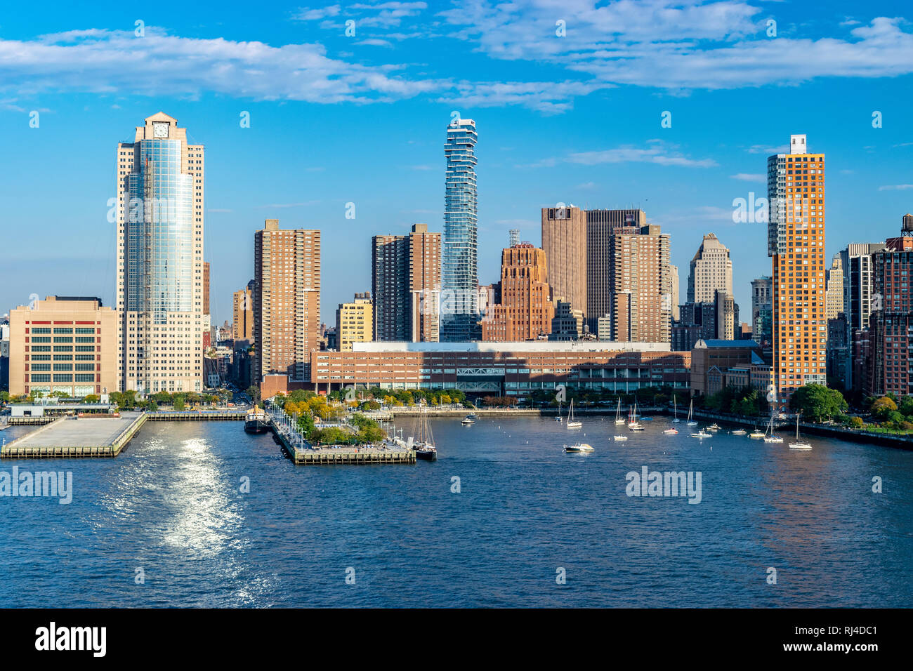 La parte inferiore di Manhattan skyline di New York City dal fiume Hudson su un soleggiato autunno serata con barche e yacht nel porto. Foto Stock