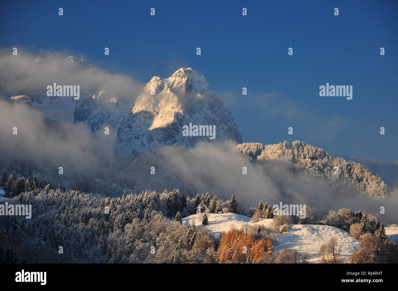 Deutschland, Bayern, Garmisch-Partenkirchen, Winterlandschaft, Bergspitzen, Bergwald, Morgensonne, Nebelschwaden Foto Stock