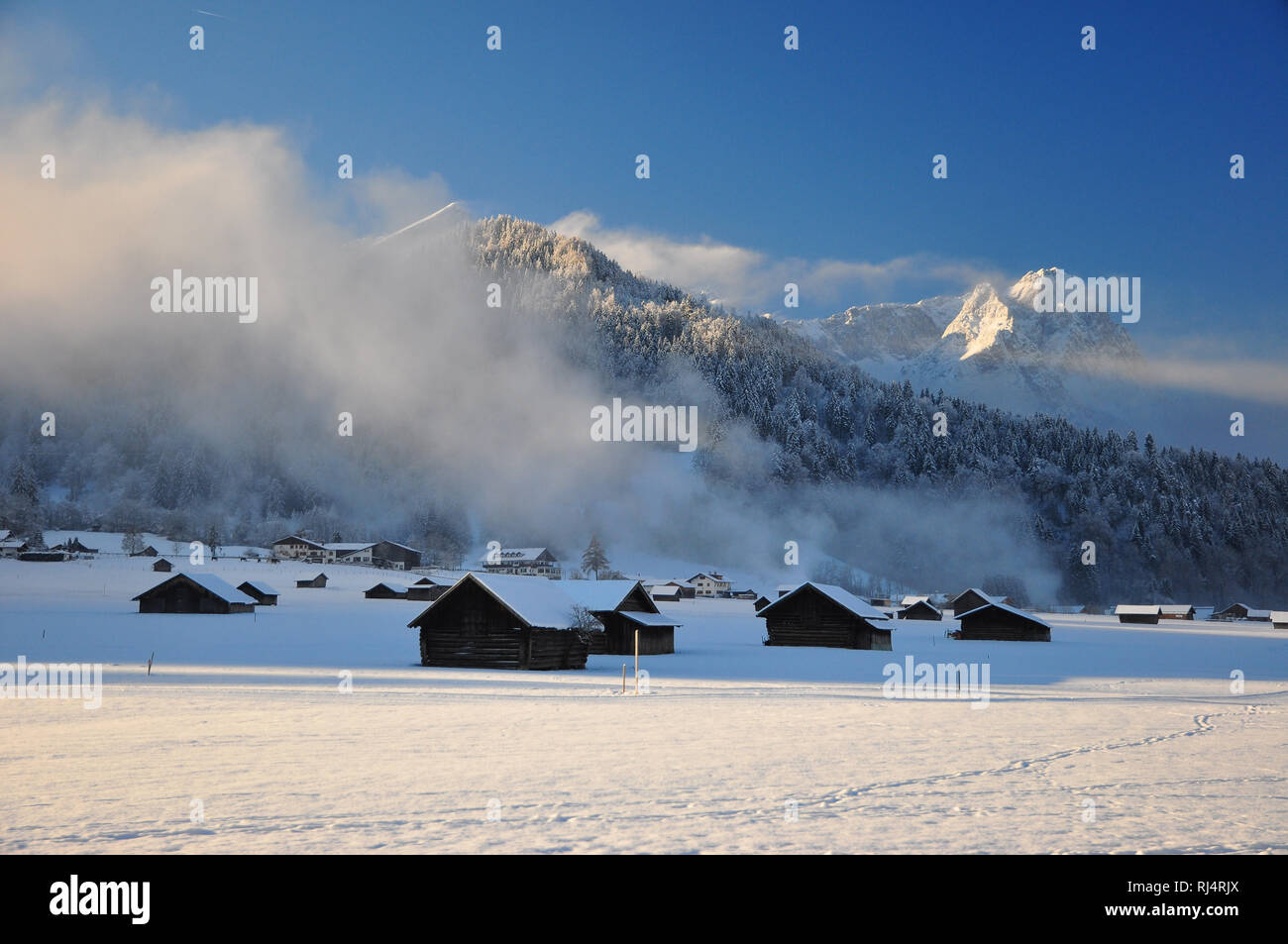 Deutschland, Bayern, Garmisch-Partenkirchen, Winterlandschaft, Bergspitzen, Morgensonne, Nebelschwaden Foto Stock