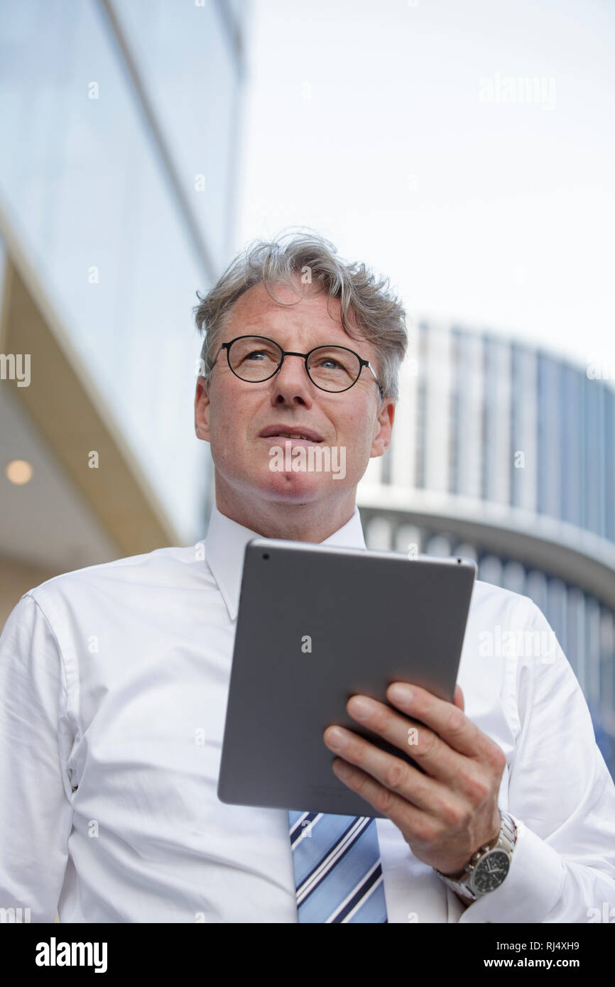 Geschäftsmann mit iPad Bürogebäude vor Foto Stock