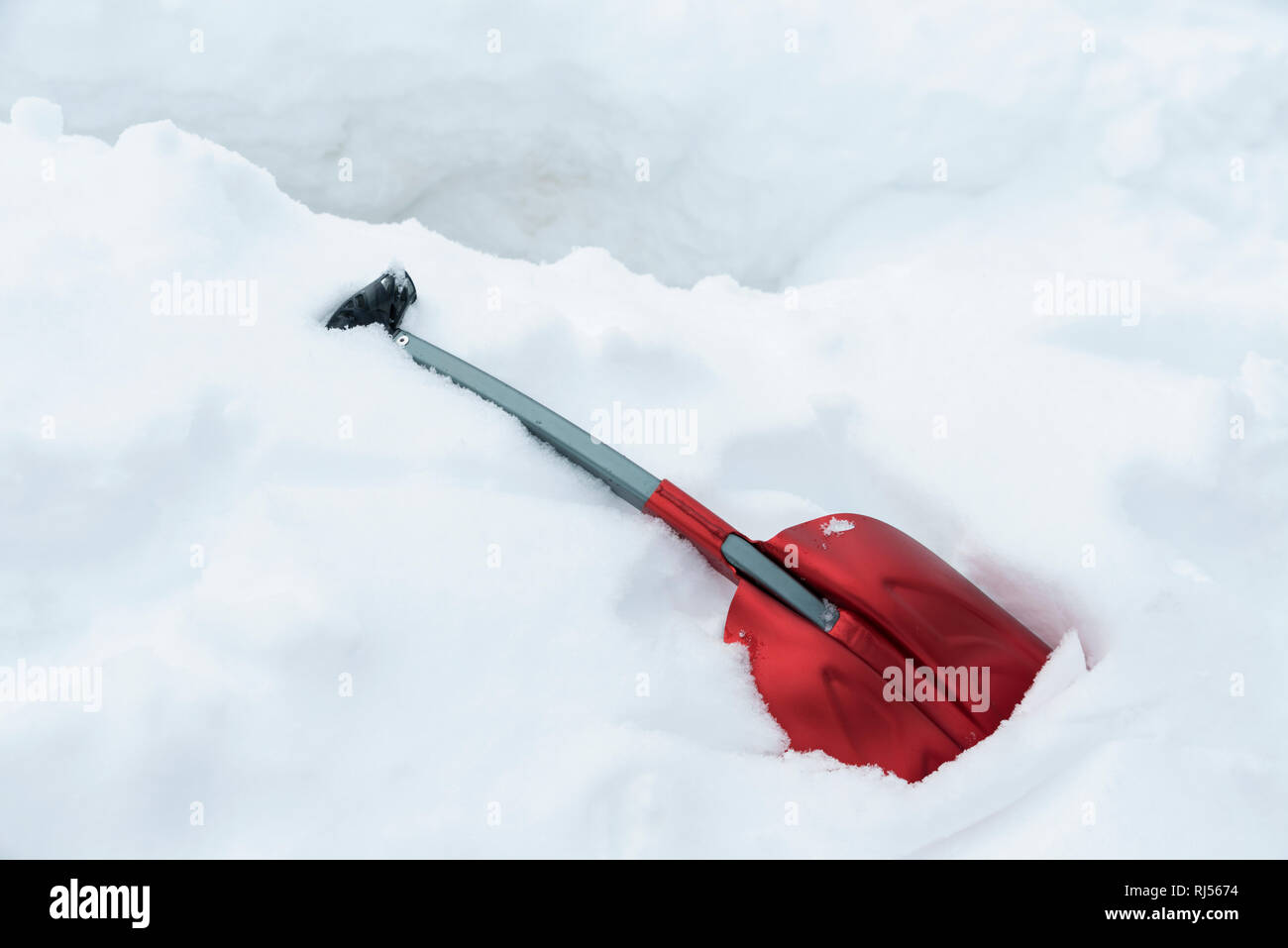 Una pala di rosso su una condotta di neve. Messa a fuoco selettiva Foto Stock
