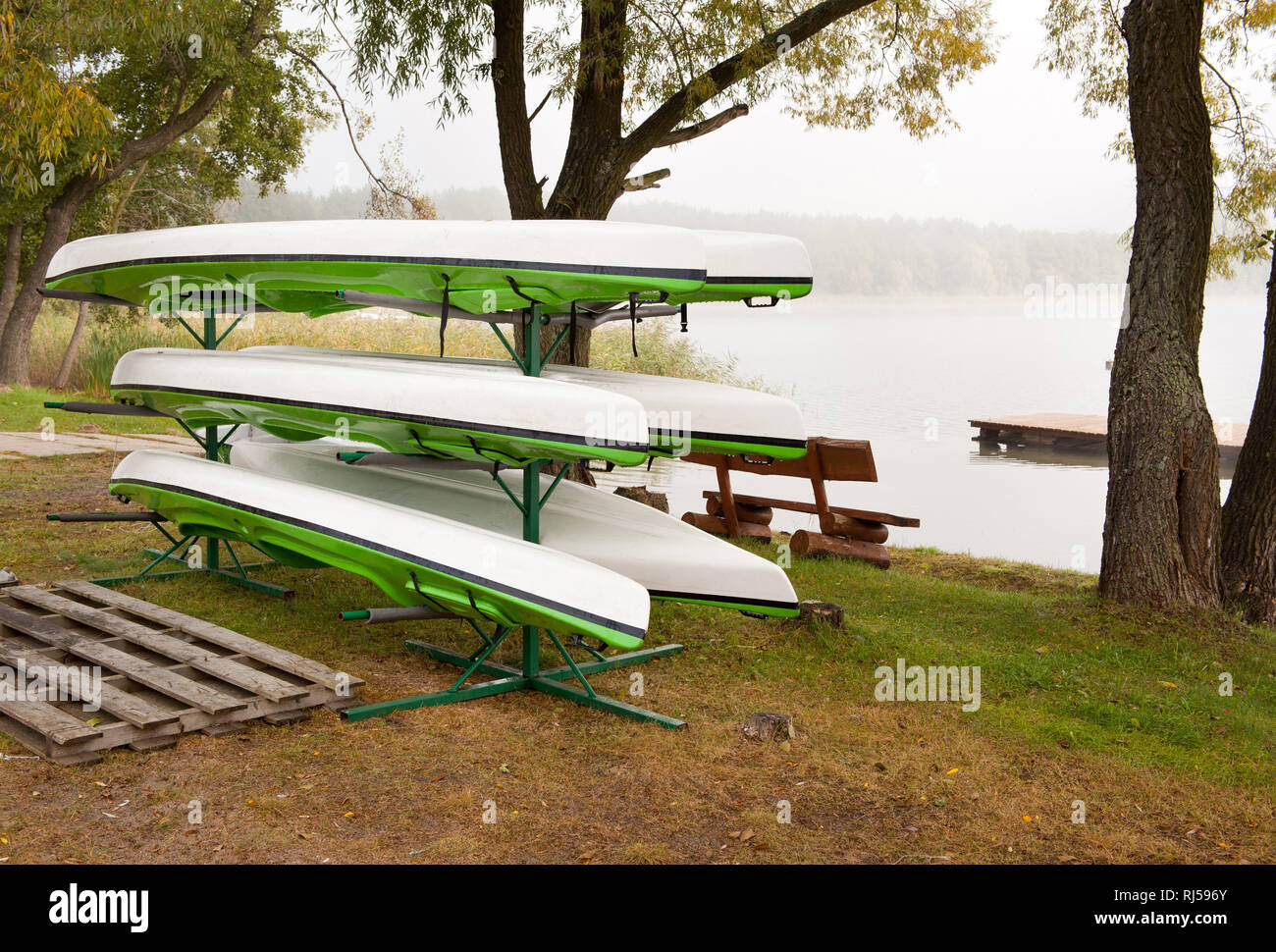 Dopo la stagione kayak essiccamento su supporto a terra in autunno, equipaggiamento da sport acquatici in attesa per i turisti in mattina nebbia autunnale, Polonia, nessuno, Foto Stock