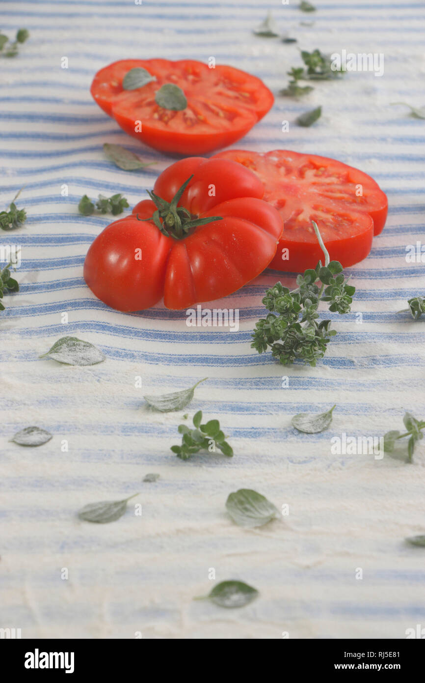 Pizzateig zubereiten mit Tomaten und griechischem origano Foto Stock