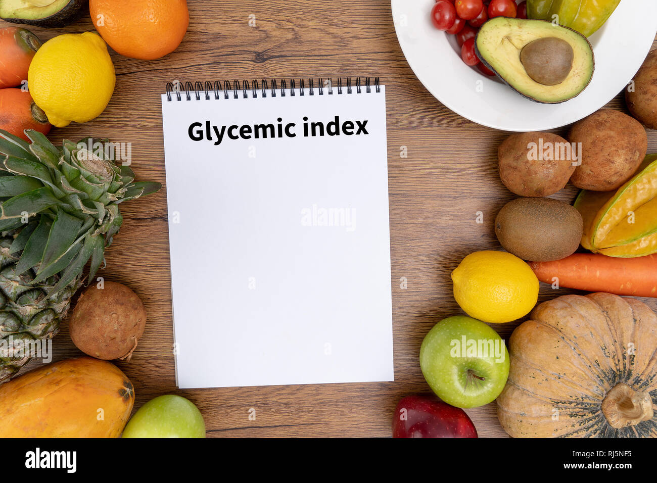 Indice Glicemico Fitness e perdita di peso concetto, manubri, bianco scala, frutta e nastro di misurazione su un tavolo di legno, vista dall'alto Foto Stock