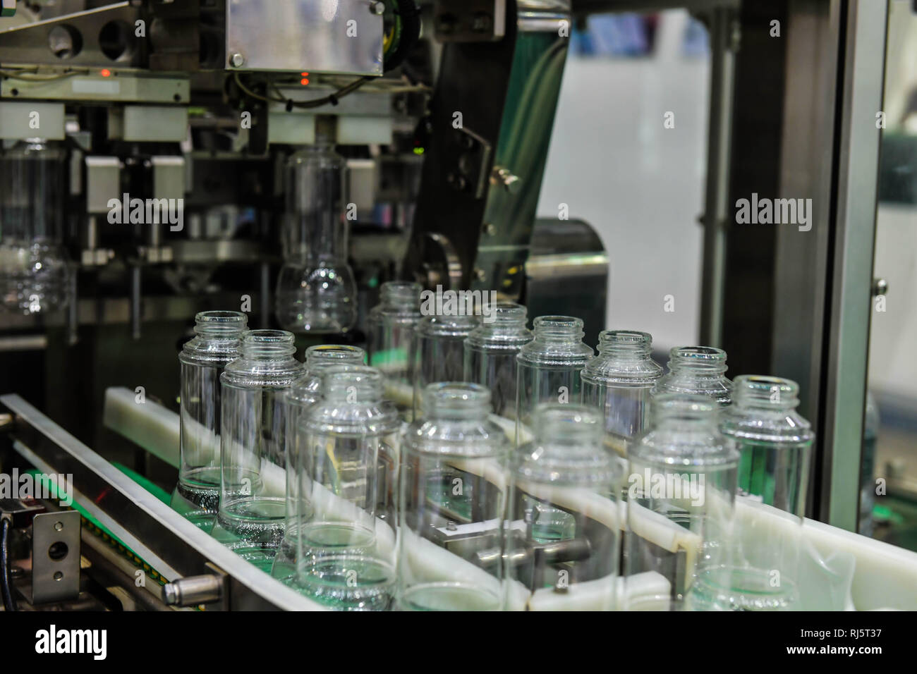 Cancellare le bottiglie di vetro trasferimento sul trasportatore automatizzato di sistemi di automazione industriale per il pacchetto Foto Stock