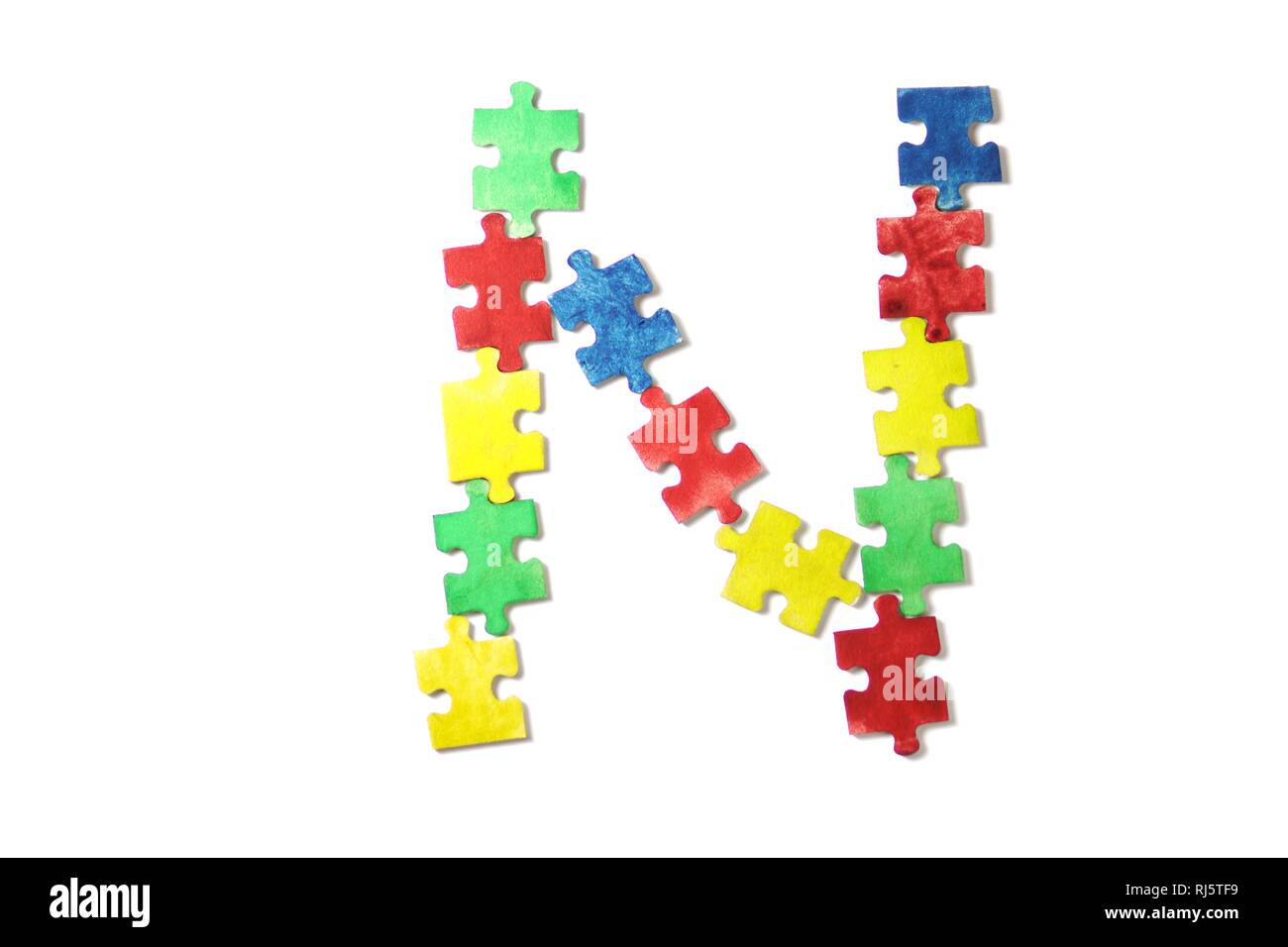 Colorato puzzle alfabeto e piastrelle con autismo word. Concetto di autismo Foto Stock