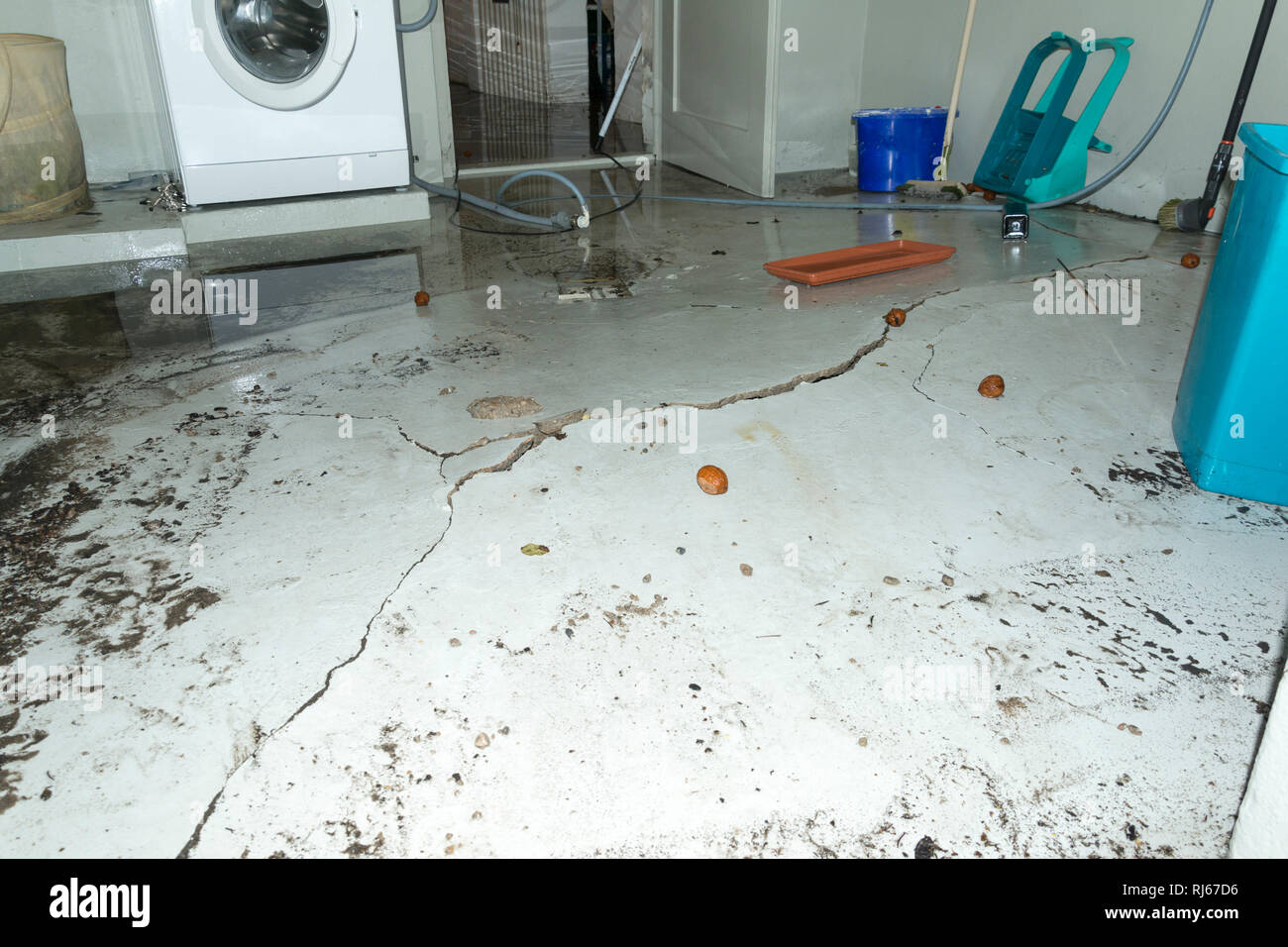 Durch Wasserdruck aufgebrochener Kellerboden nach einem Starkregen Foto Stock