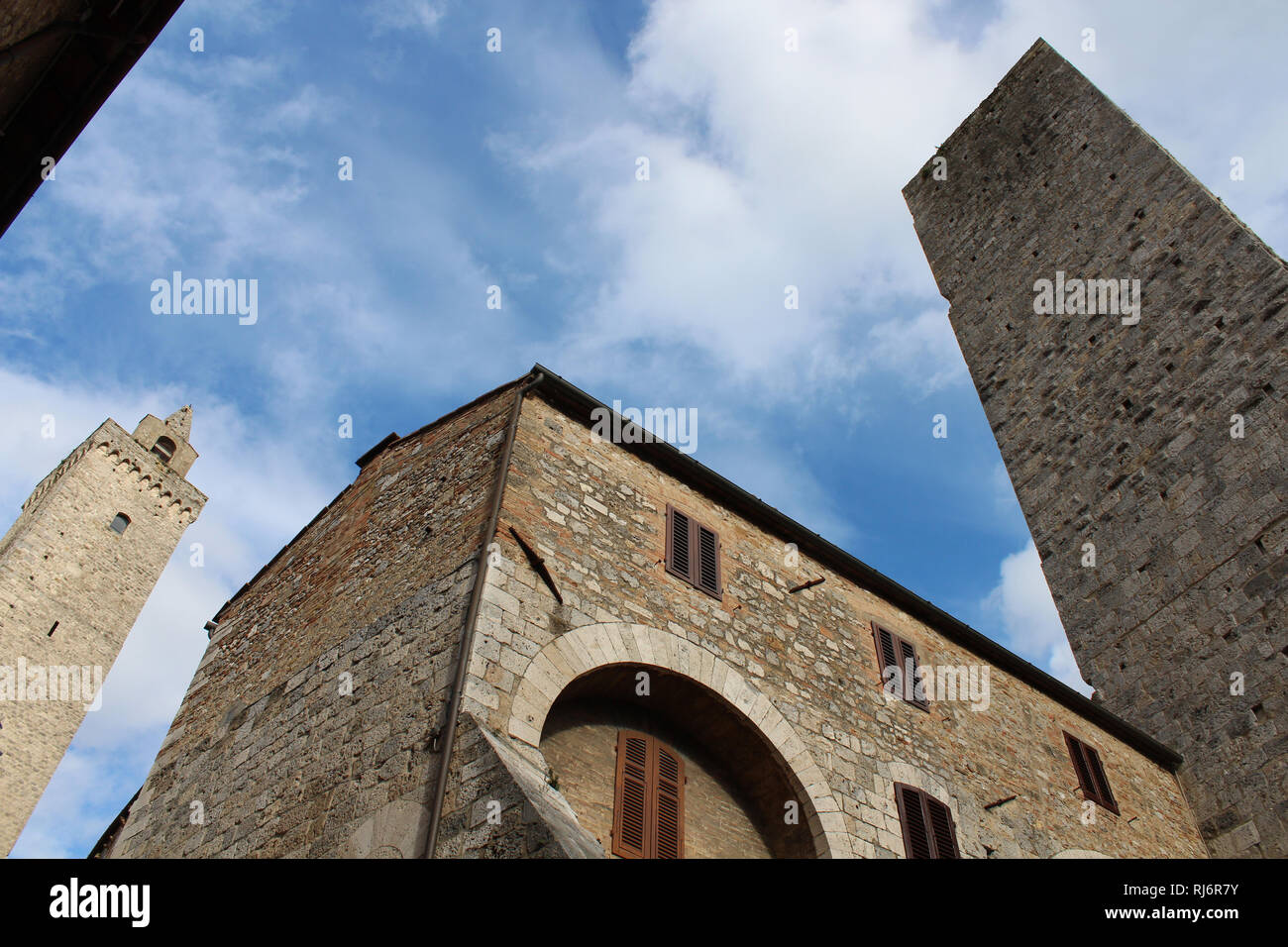 Le torri medievali di San Gimignano di raggiungere il cielo in una terra al cielo immagine in prospettiva. Foto Stock
