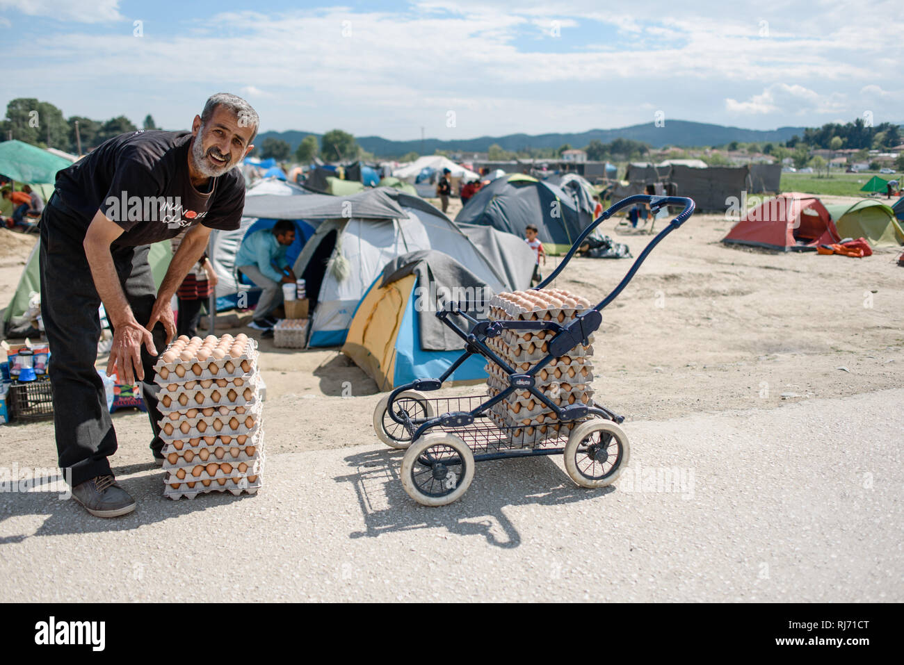 Ein Mann bringt eine neue Lieferung Eier. Flüchtlingscamp von Idomeni in Griechenland an der Grenze nach Mazedonien, aprile 2016. Foto Stock
