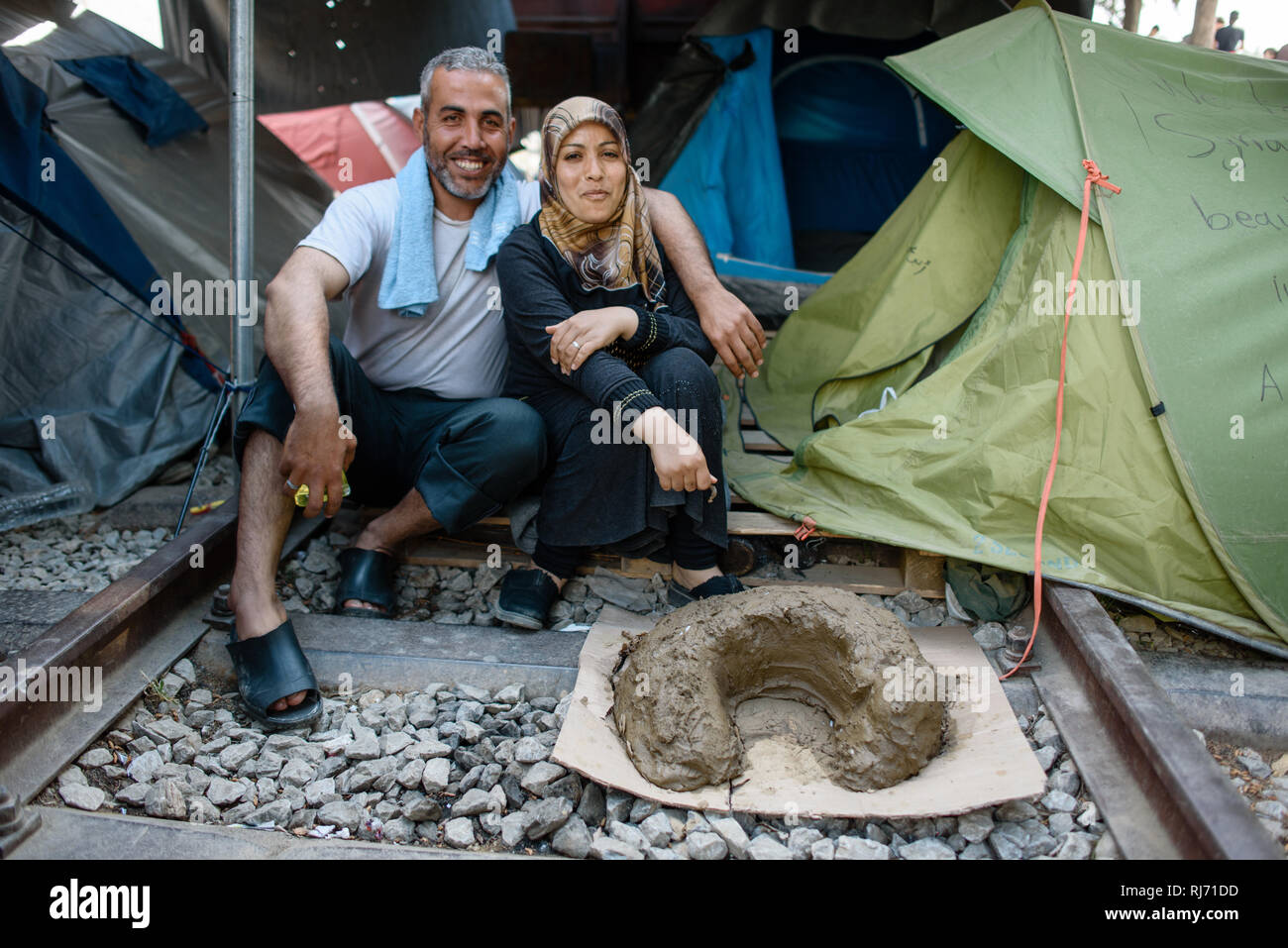 Ein Ehepaar aus Syrien Flüchtlingscamp im von Idomeni in Griechenland an der Grenze nach Mazedonien, aprile 2016. Dieses Gebilde im Vordergrund ist ein Foto Stock