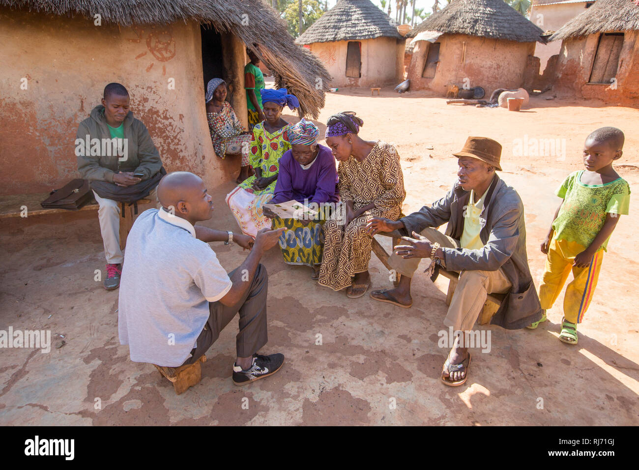 Bodadiougou Village, Banfora, Cascades Region, Burkina Faso, 4th dicembre 2016; Simon Kam, Chief Medical Officer per il distretto, spiega a Godima Siri e alla sua famiglia estesa perché è importante che tutti i membri della famiglia prenda Ivermectin per prevenire La Cecità del fiume. Foto Stock