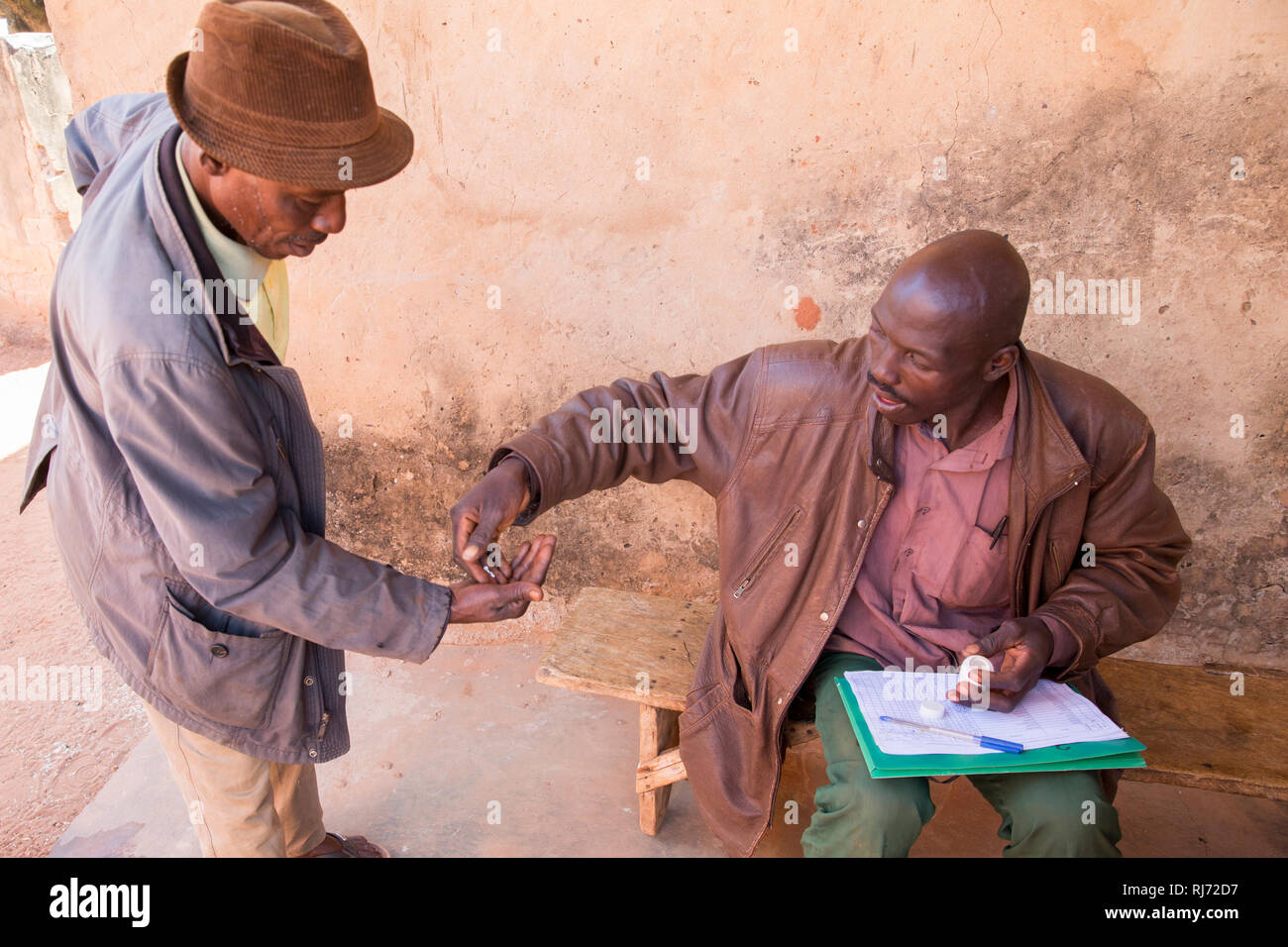 Bodadiougou Village, Banfora, Cascades Region, Burkina Faso, 4th dicembre 2016; distribuzione di Ivermectin a Godima Siri con il distributore comunitario Soungalo Siri (seduto). Questo fa parte del programma per prevenire La Cecità del fiume nella regione. Foto Stock