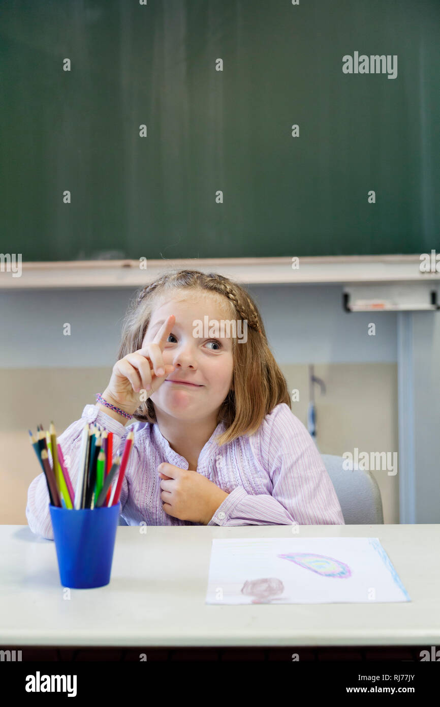 Schülerin, 7 Jahre alt, mit keckem Gesichtsausdruck, meldet sich Foto Stock