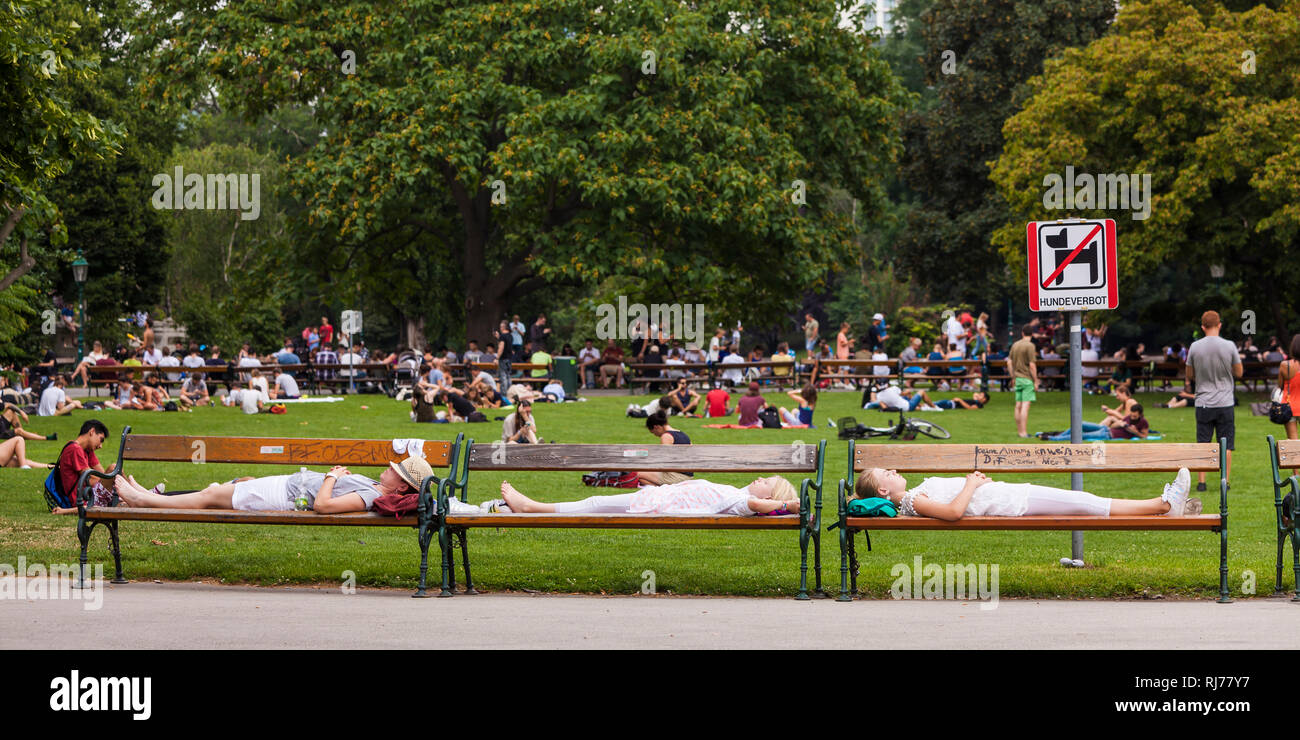 Österreich, Wien, Stadtpark, Frau und zwei Mädchen auf Parkbänken, Menschen im Park, ausruhen, pausa Foto Stock
