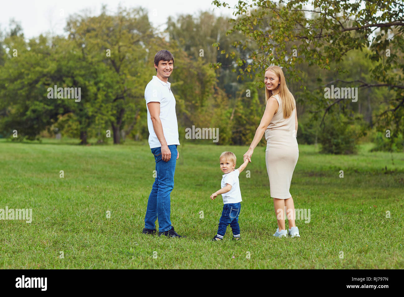 La famiglia felice giocando con il bambino nel parco. Foto Stock