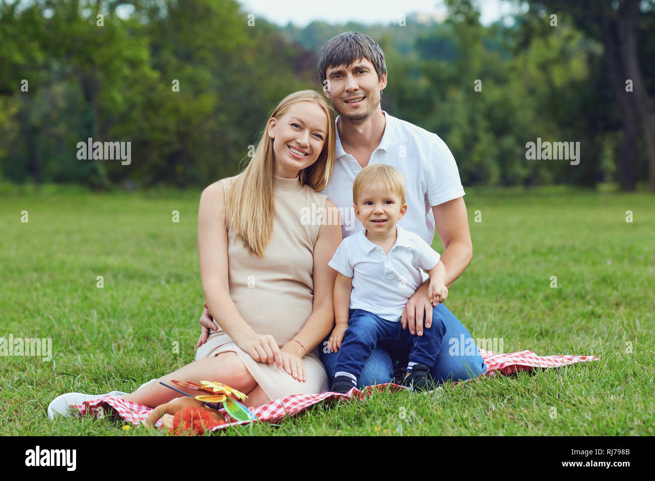 La famiglia felice insieme nel parco d'estate. Foto Stock