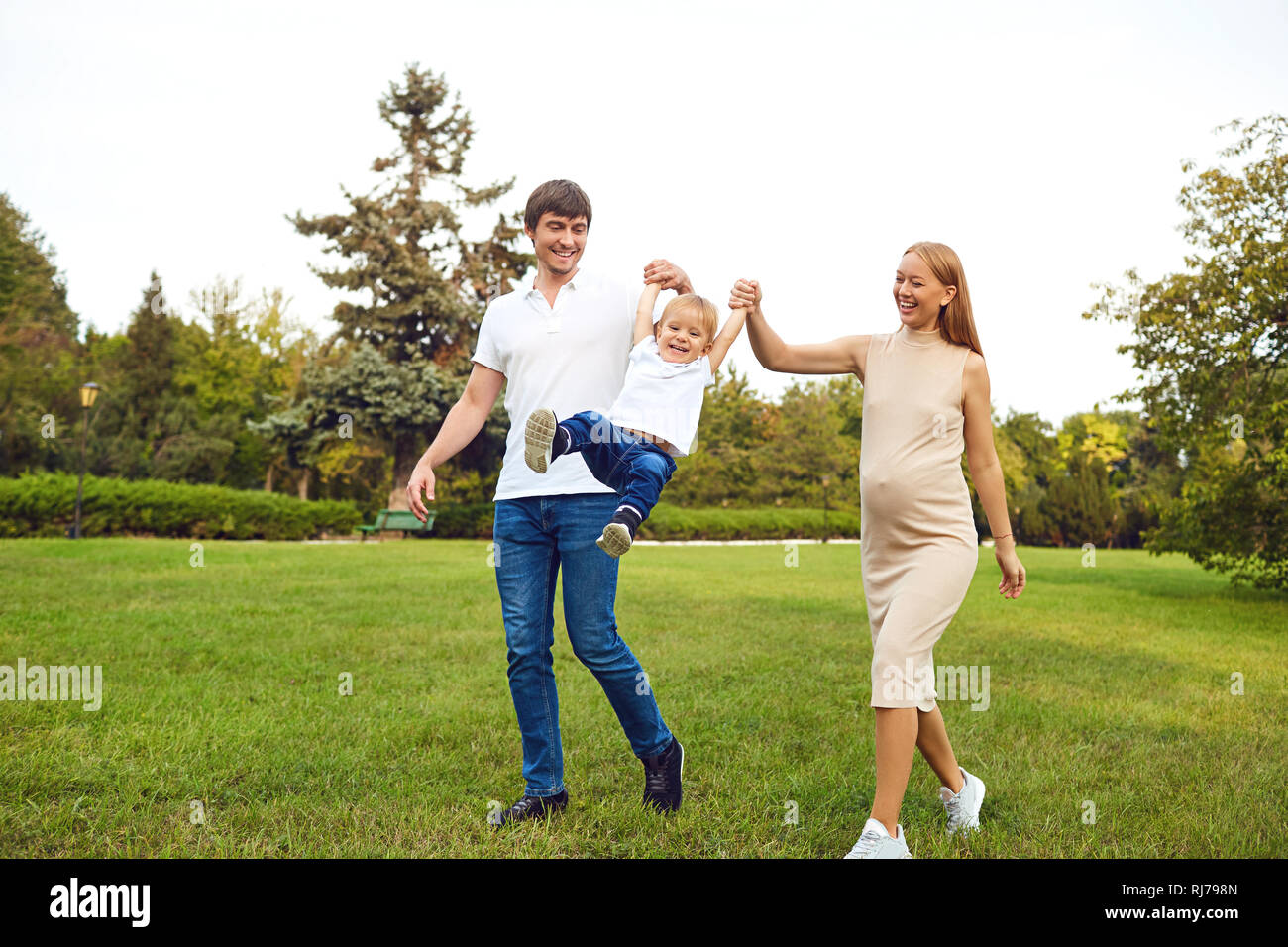 La famiglia felice giocando con il bambino nel parco. Foto Stock