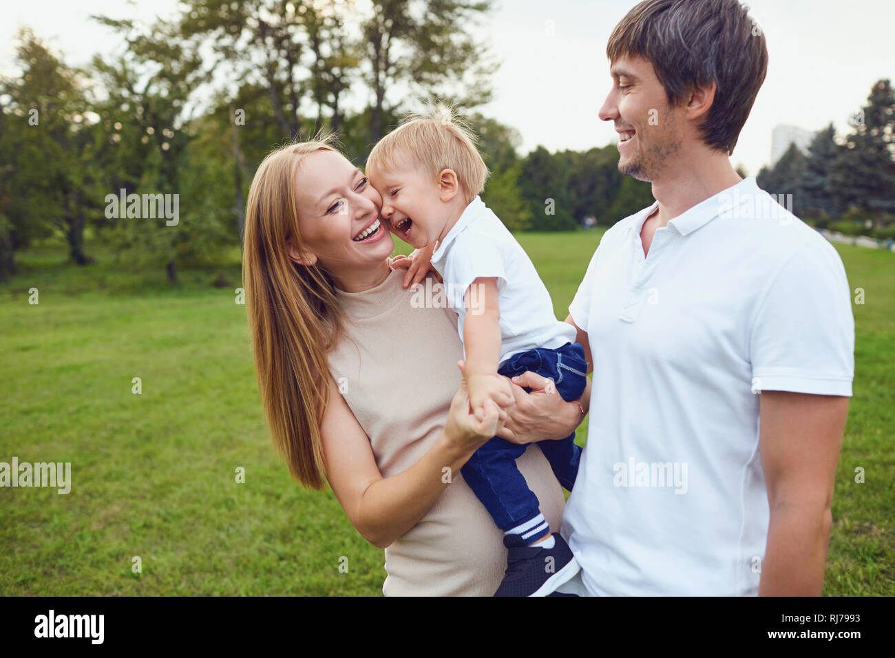 La famiglia felice è ridere nel parco. Foto Stock