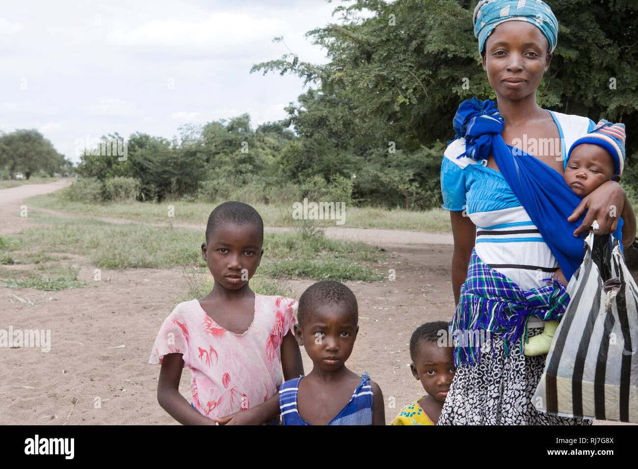 Frau mit 4 Kindern am Straßenrand Foto Stock