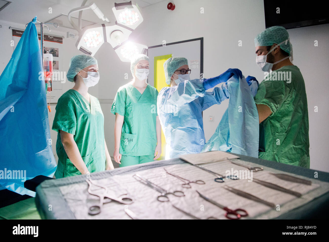 Hannover, Germania. 05 feb 2019. Nel 'Succide Lab' di Hannover Medical School (MHH), studenti di medicina pratica la igienicamente corretto mettere su di un abito chirurgico in una replica in sala operatoria (scena). Nelle competenze del laboratorio di informatica MHH, medico gli studenti possono imparare pratiche e tecniche invasive di competenze mediche - e mettere in pratica la comunicazione tra medici e pazienti. Credito: Julian Stratenschulte/dpa/Alamy Live News Foto Stock