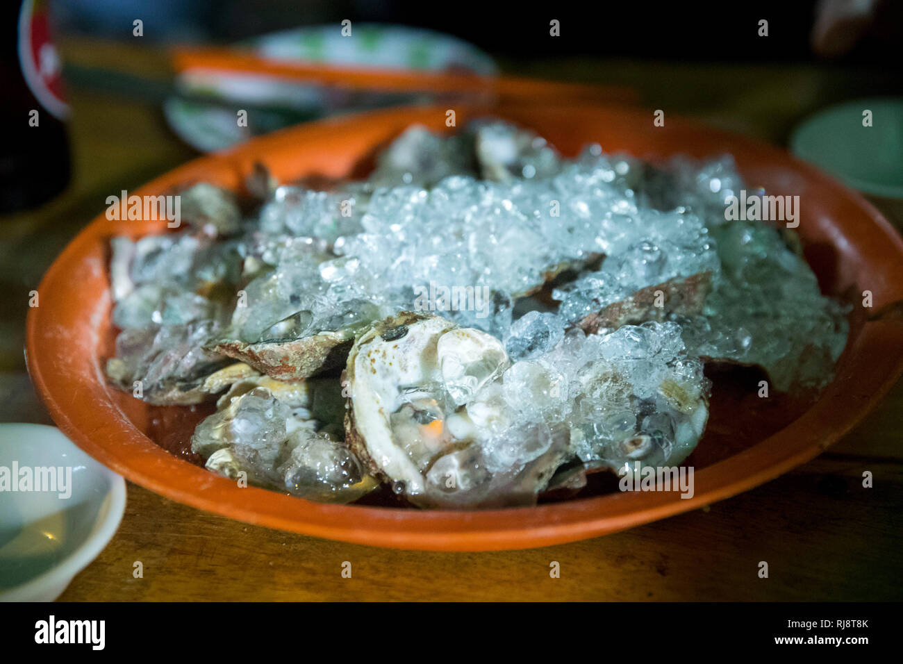 Kambodscha, Phnom Penh, Straßenrestaurant 'Oyster House', es wird auf der Straße gekocht und gegessen, sehr leckere Meeresfrüchte und Fisch, Austern un Foto Stock