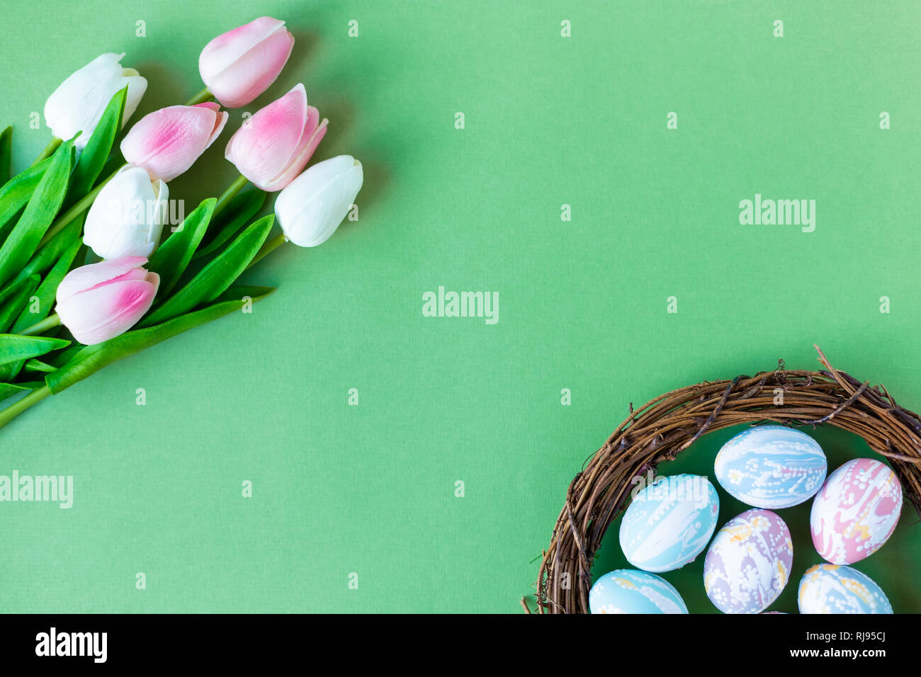 Tulipani e uova di pasqua su uno sfondo verde spazio Copia vista superiore Foto Stock
