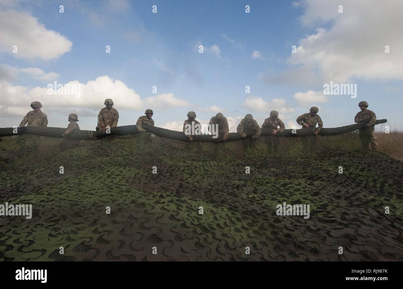 Stati Uniti I soldati dell esercito con il 5° 7° Battaglione di difesa aerea Reggimento di Artiglieria Roll up camouflage netting durante un "Patriot Shock" esercizio di Capu Midia, Romania il 5 novembre 2016. Il giro delle prove di esercizio dell'unità di risposta rapido deployment readiness e aumenta l interoperabilità con "Patriot" Missile Systems e i loro partner rumeno. Foto Stock