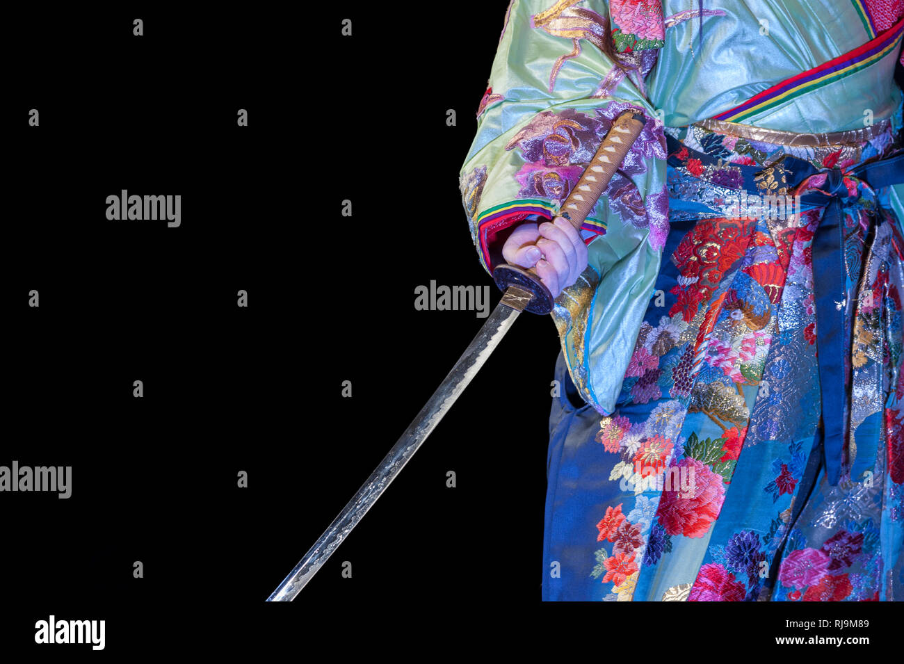Giapponese whit ballerino multicolore di kimono e katana spada, durante uno spettacolo. Foto Stock