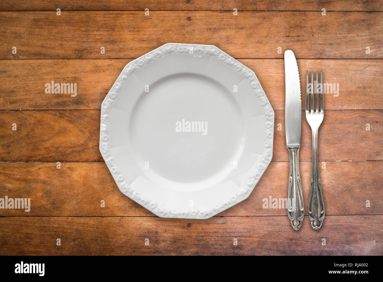 Piastra vuota , forchetta e coltello sul tavolo di legno Foto Stock