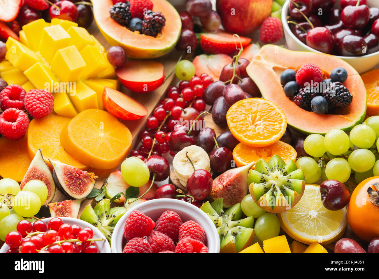 Taglio Sano frutta sfondo, Fragole Lamponi arance Prugne Mele Kiwi uva ribes rosso mirtilli persimmon mango Foto Stock