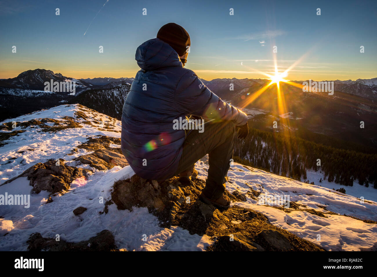Deutschland, Bayern, Bayerische Alpen, Wanderer genießt Sonnenaufgang auf dem Jochberg Foto Stock