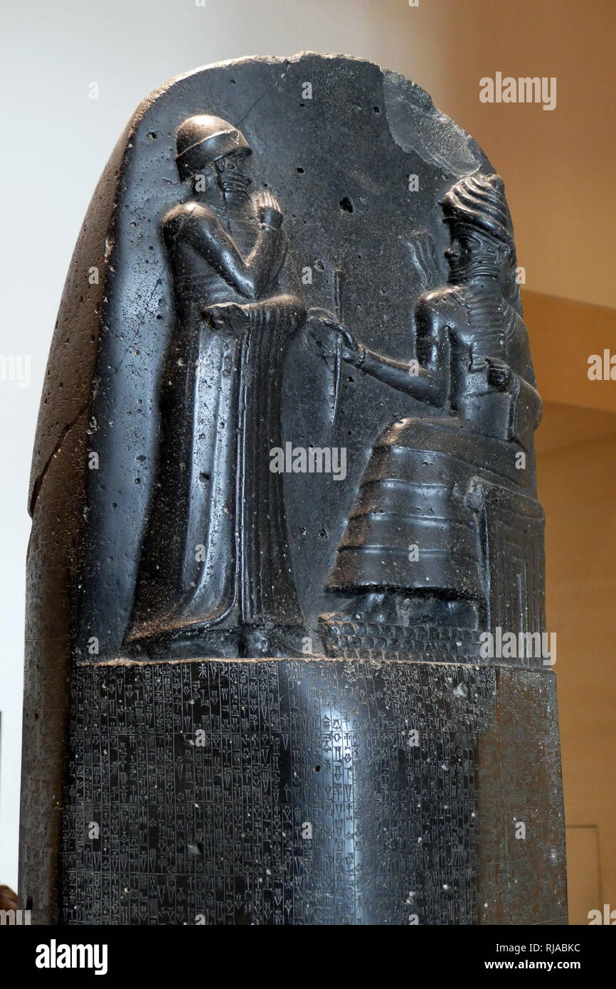Stele in basalto nero raffiguranti il codice di Hammurabi; 1792-1750 A.C. Hammurabi il codice era un corpo babilonese della legge scritta per antica Mesopotamia. Nella parte superiore della stele è Hammurabi (in piedi), raffigurata ricevendo la sua royal insegne da Shamash (o eventualmente Marduk). Hammurabi mantiene le sue mani sulla sua bocca come un segno della preghiera Foto Stock