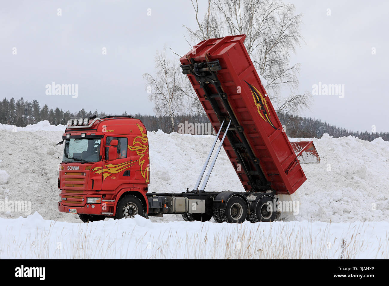 Salo, Finlandia - 2 Febbraio 2019: Rosso Scania R580 ribaltabile elevatore scarica snow cancellato dalle strade e parcheggi comunali neve area di dumping. Foto Stock