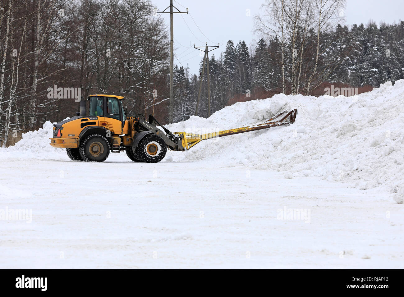 Salo, Finlandia - 2 Febbraio 2019: Volvo L45F della pala caricatrice gommata neve con attrezzatura di sollevamento al lavoro al comunale di dumping neve area nel sud della Finlandia. Foto Stock