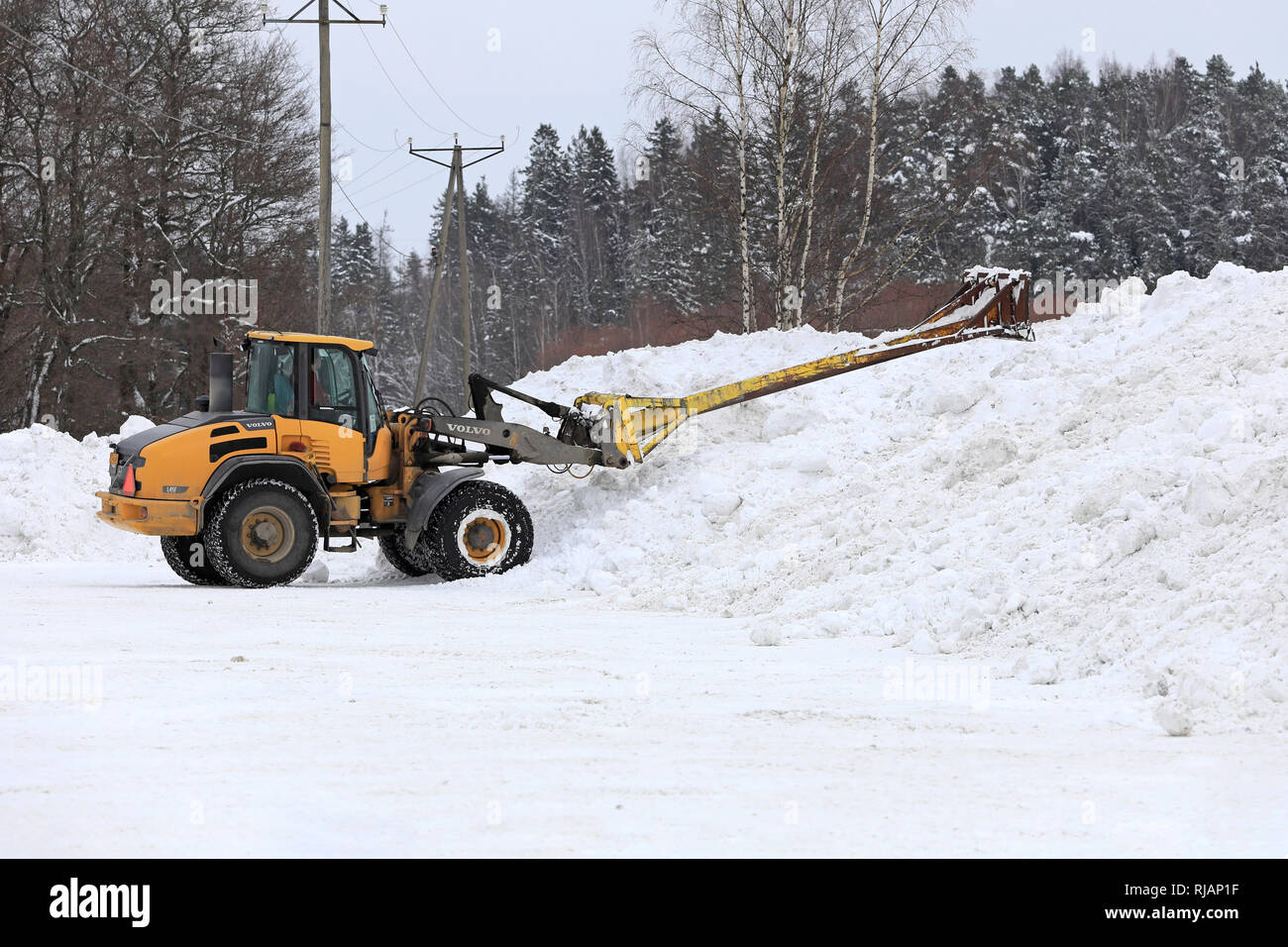 Salo, Finlandia - 2 Febbraio 2019: Volvo L45F della pala caricatrice gommata neve con attrezzatura di sollevamento al lavoro al comunale di dumping neve area nel sud della Finlandia. Foto Stock