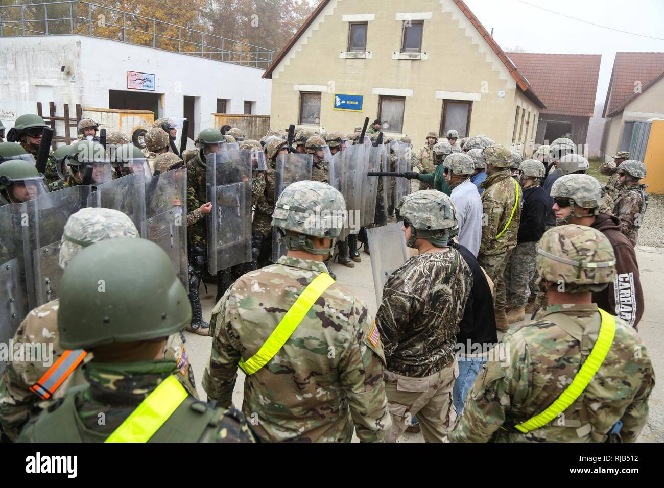 Soldati rumeni di 265Polizia Militare Battaglione e soldati armena della terza compagnia di fanteria, 2° battaglione di fanteria preparare per impegnare U.S. I soldati del primo battaglione, 4° Reggimento di Fanteria role-playing ostile civili durante la conduzione di una folla antisommossa scenario durante una forza per il Kosovo (KFOR) Missione prove generali di esercizio (MRE) al giunto multinazionale Centro Readiness in Hohenfels, Germania, nov. 4, 2016. La KFOR MRE 22 è progettato per preparare il trentasettesimo della brigata di fanteria combattere Team per il sostegno della pace e della stabilità e del contingente della cooperazione in Kosovo a sostegno delle autorità civili in ma Foto Stock