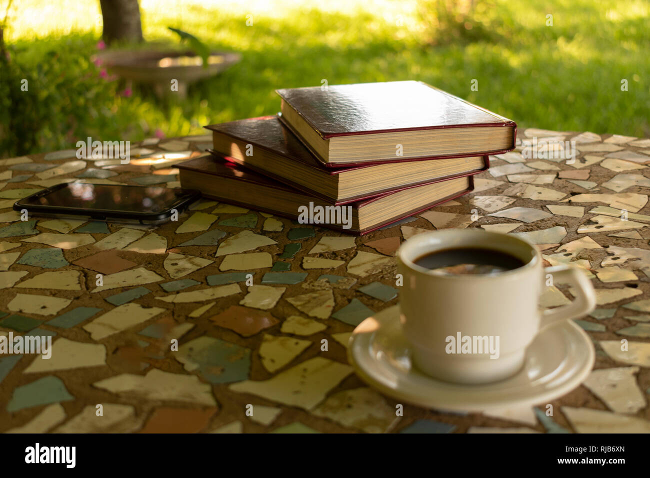 Libri su un tavolo accanto a una tazza di caffè Foto Stock