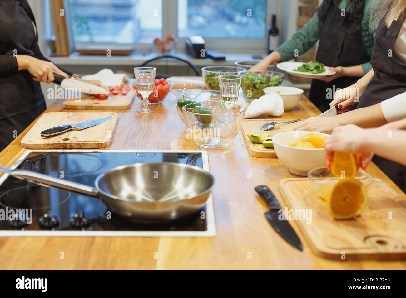 Multirazziale amici divertenti cuocere qualche gustoso cibo in cucina mentre si beve vino. Foto Stock