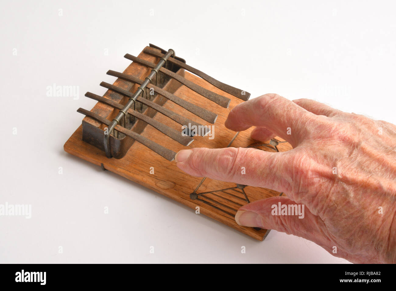 Vecchia mano su un pollice africana pianoforte. Kalimba, mbira.La mbira è un africano lo strumento musicale costituito da un pannello di legno con annesso sfalsate soddisfatte Foto Stock